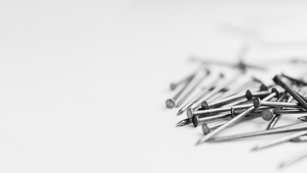 Pile of metallic nails on white table