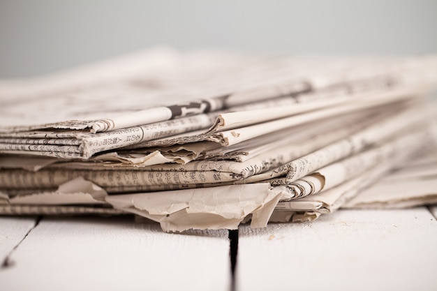 Free Photo pile of newspapers on a white table