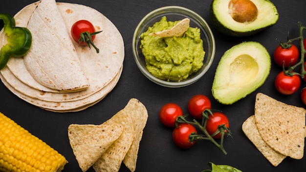 Free photo pile of pita near vegetables and sauce with nachos