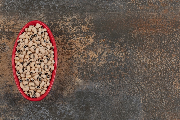 Free photo pile of raw white beans in red bowl.