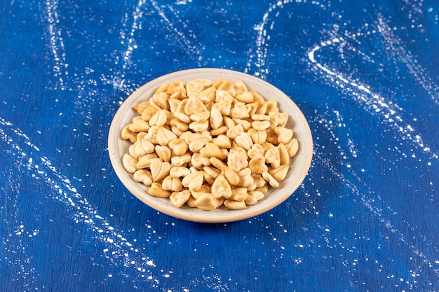 Pile of salted heart-shaped crackers placed on ceramic plate