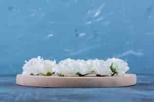 Free photo pile of small white flowers placed on blue.