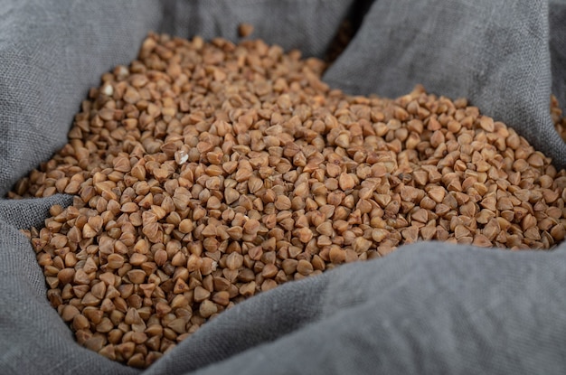 Free photo pile of uncooked buckwheat in gray cloth