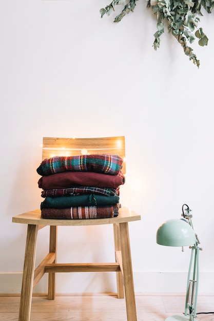 Free Photo pile of winter sweaters on chair 