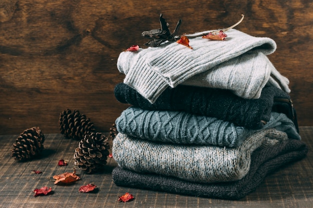 Pile of winter sweaters with pine cones