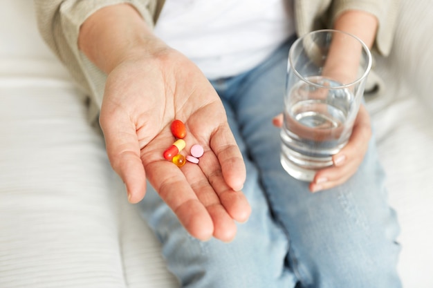 Pills, tablets, vitamins and drugs heap in mature hands