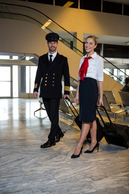 Free Photo pilot and air hostess walking with their trolley bags