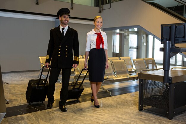 Pilot and air hostess walking with their trolley bags