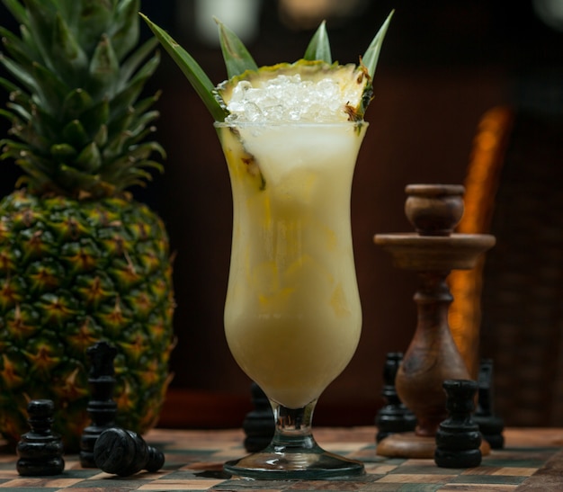 Pinapple ice cold cocktail glass on a chess board