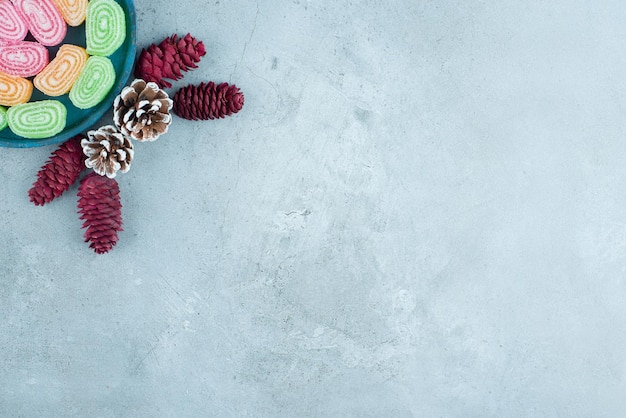 Free photo pine cone arrangement and a platter of marmelades on marble.