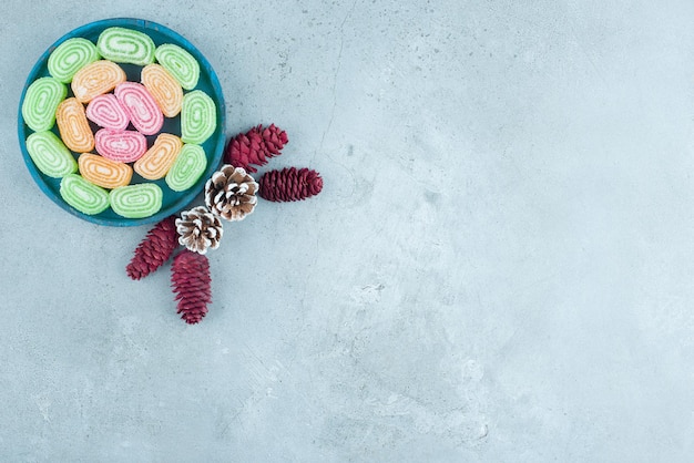 Pine cone arrangement and a platter of marmelades on marble.