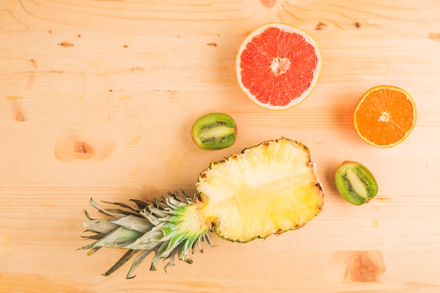 Free photo pineapple and citrus fruits on wooden table