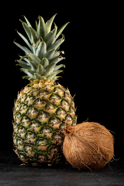 Pineapple coco fresh mellow ripe fruits isolated on dark floor