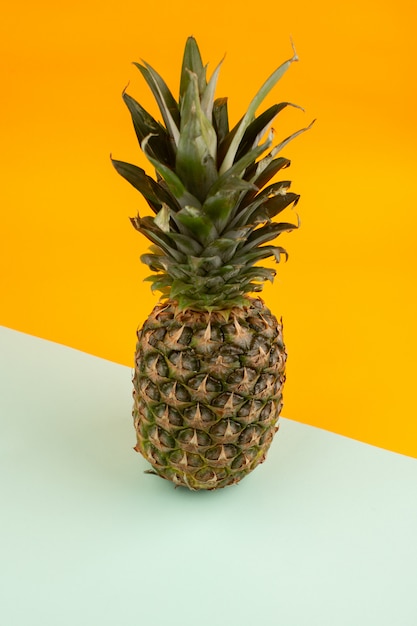 Free photo pineapple whole tasty sour on a water green and orange