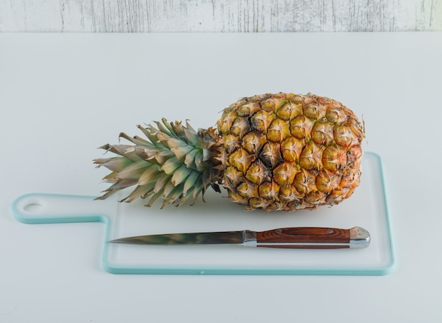 Pineapple with cutting board and knife