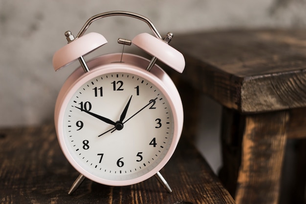 Pink alarm clock on wooden table