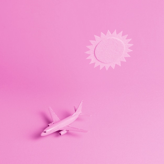 Pink background with plane and sun