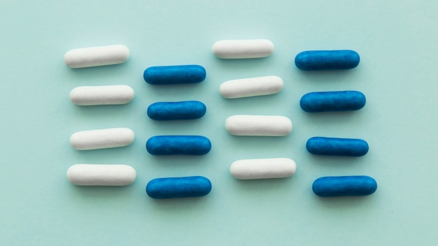 Free photo pink and blue candies arranged in row over the colored backdrop