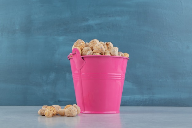 A pink bucket full of delicious dried fruit .