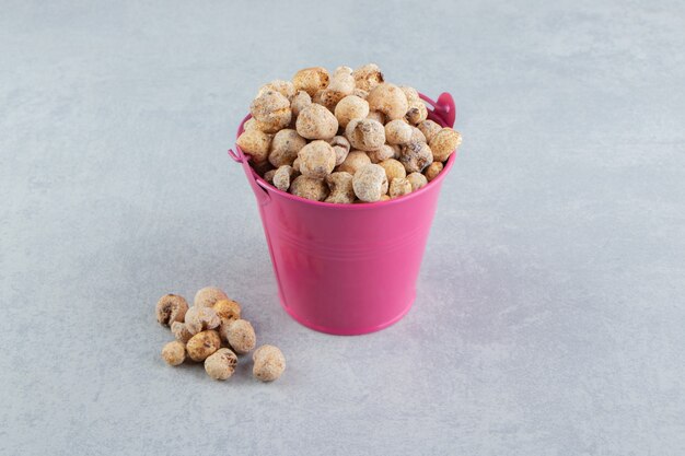 A pink bucket full of delicious dried fruit .