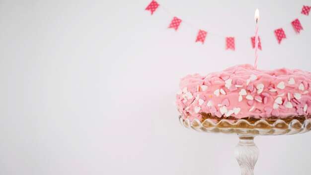 Free photo pink cake decorated with candle