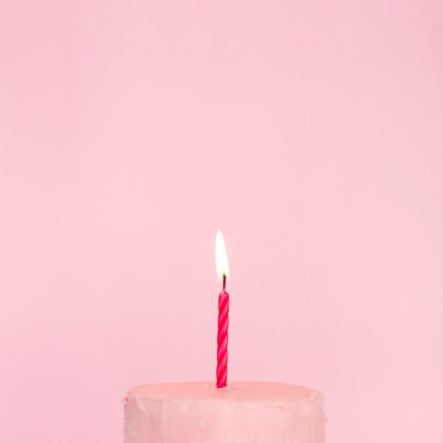 Free photo pink cake with lit candle