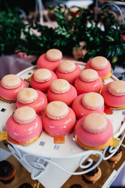 Pink cakes with macaroons served on a plate