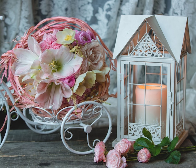 Free photo pink candle in a fake cage, small wreath of flowers.