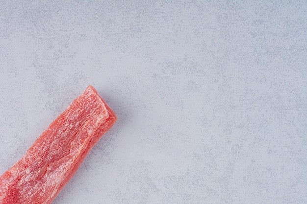 Pink cherry marmelade sticks on concrete background.