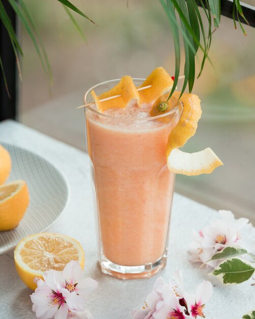 Pink cocktail with lemon and flowers.