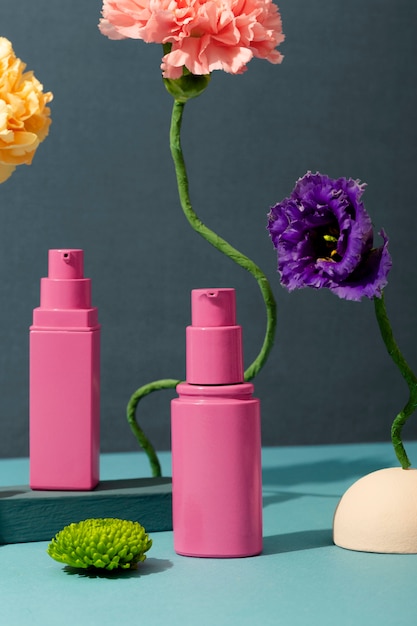 Free photo pink cosmetic containers and flowers