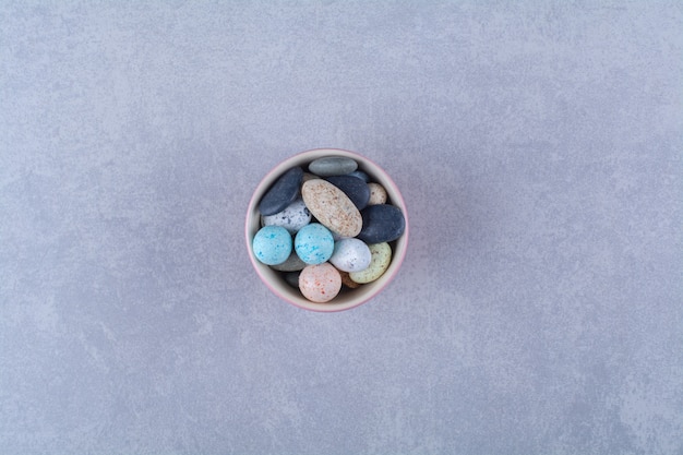 A pink cup full of colorful bean candies . High quality photo