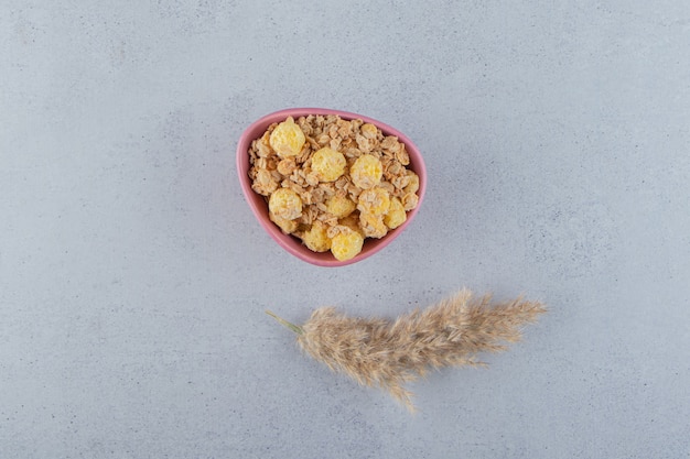 Free photo a pink deep bowl of delicious healthy cereals on gray background . high quality photo