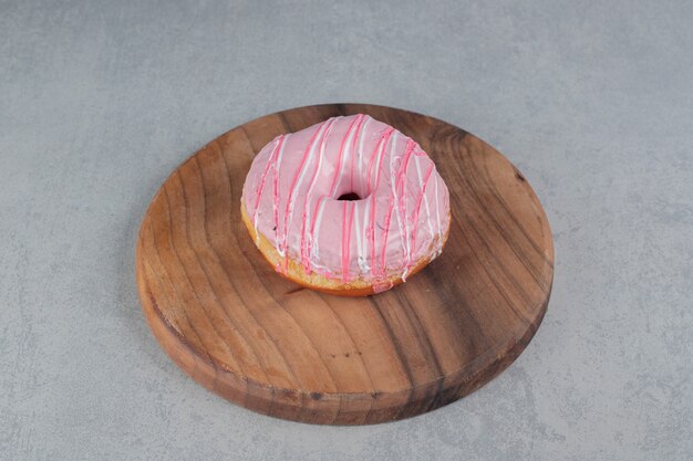 Pink doughnut isolated on a concrete surface