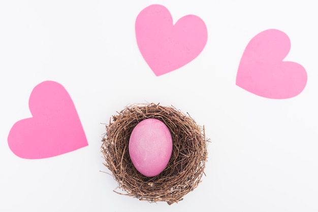 Pink Easter egg in nest on table