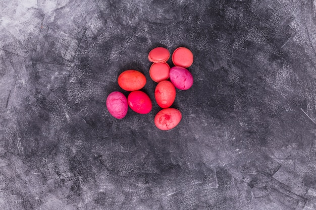 Free photo pink easter eggs with macaroons on table