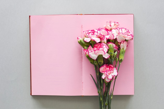 Pink flowers bouquet on notebook on table