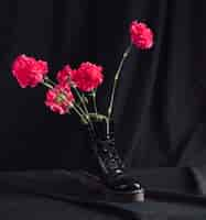 Free photo pink flowers in dark boot