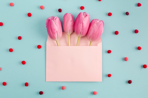 Pink flowers in envelope among soft confetti