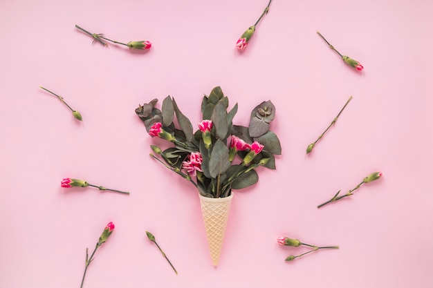 Free Photo pink flowers in waffle cone on table