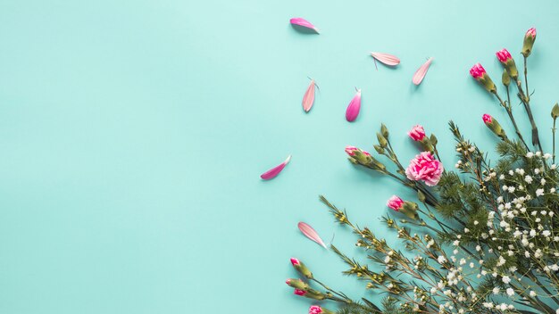 Pink flowers with plant branches on table