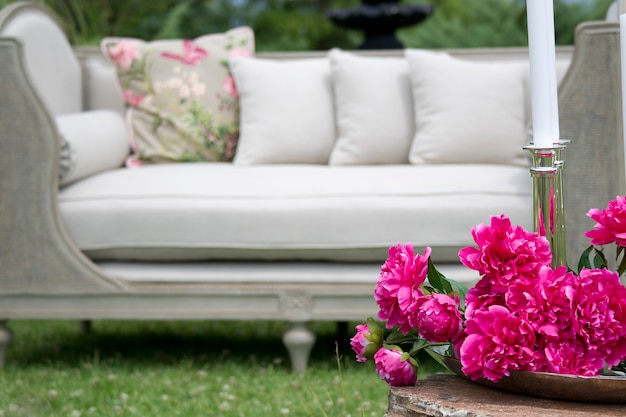 Free photo pink flowers with a white sofa background