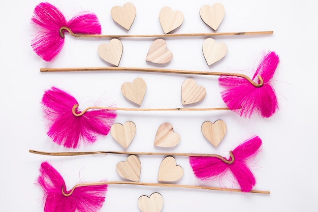 Free photo pink flowers with wooden hearts on white table