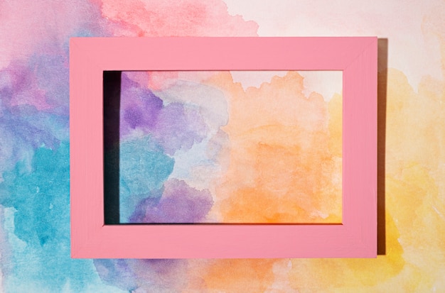 Free photo pink frame on painted background top view