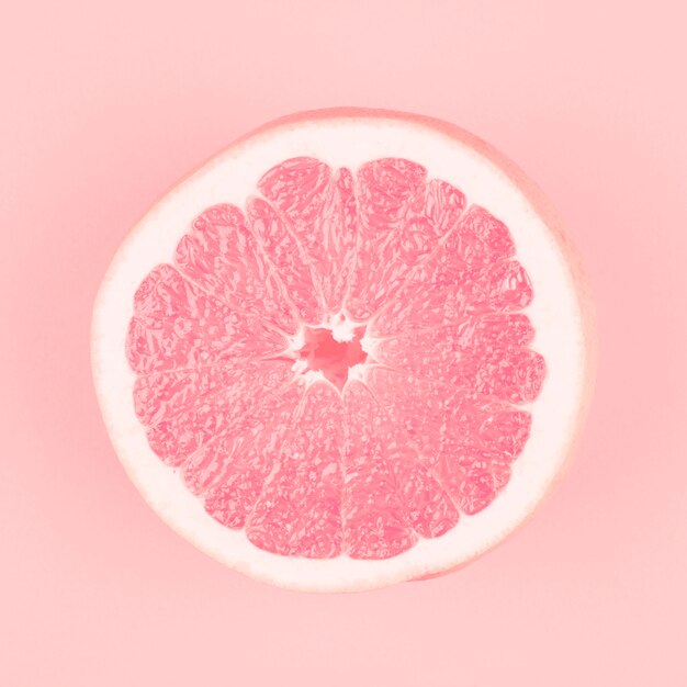 Pink halved fresh juicy grapefruit on pink background