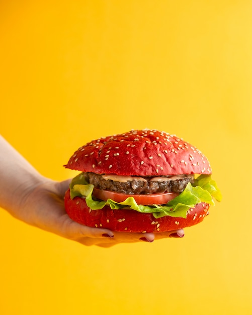 pink hamburger a woman holding burger with tomato lettuce leaf beef patty and sauce in burger buns