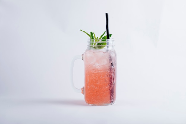 Free photo pink juice with ice cubes and mint inside glass jar.