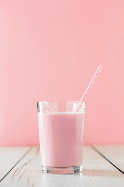 Pink milkshake in glass with straw