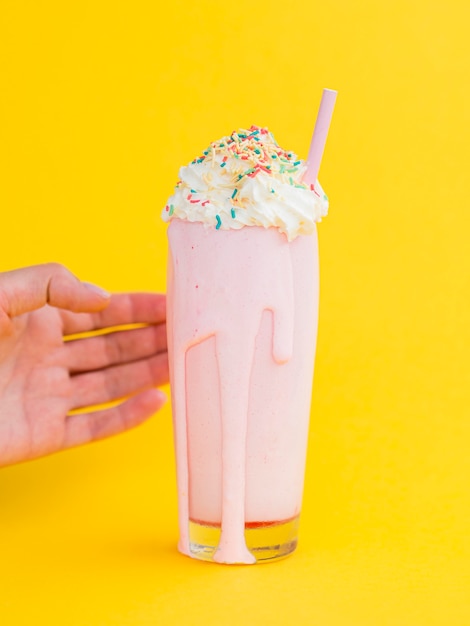 Free photo pink milkshake with yellow background