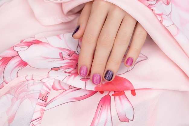 Free photo pink nail design. female hand with glitter manicure.